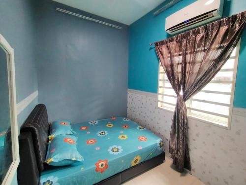a bedroom with a bed with blue walls and a window at RIZQI HOMESTAY Sungai Siput with Wifi! Islamic Guest Only! in Kampong Rimba Panjang