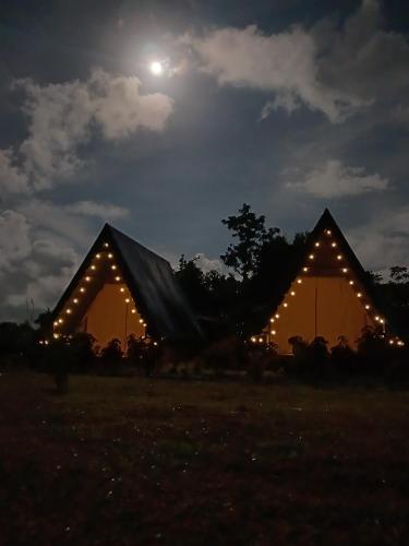 two tents lit up at night with the moon in the sky at Flora Glamping de Abuela in Fortuna