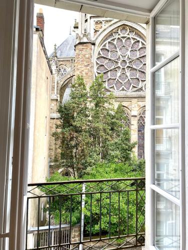 een open raam met uitzicht op een kerk bij Cozy Talensac in Nantes