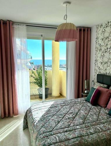 ein Schlafzimmer mit einem Bett und einem großen Fenster in der Unterkunft Panoramic Seaview in Mijas