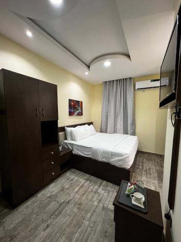 a hotel room with a bed and a tv at Fragrance Apartments and Suites in Ibadan