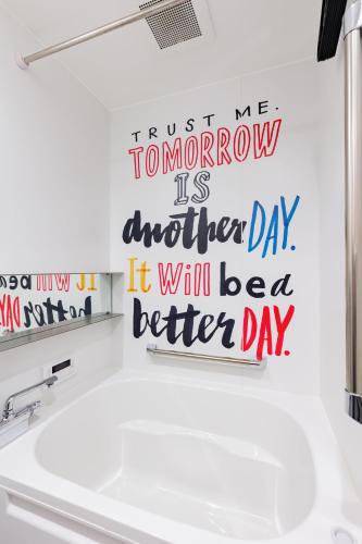 a bathroom with a sink and a sign that reads trust me tomorrow is another day at vacation rental SARAKU 茶楽来 in Osaka