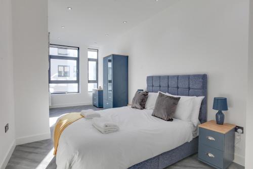 a bedroom with a large bed with a blue headboard at CityView Executive Apartments Southend in Southend-on-Sea