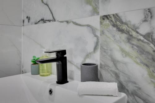 ein Badezimmer mit einem Waschbecken und einem Wasserhahn in der Unterkunft CityView Executive Apartments Southend in Southend-on-Sea