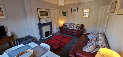 a living room with a couch and a fireplace at Morris Terrace Apartment in Stirling