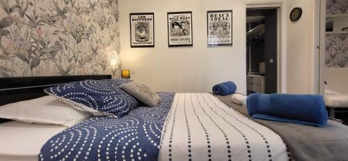 un lit avec des draps et des oreillers bleus et blancs dans l'établissement Cannes apartment - city center, AC / wifi, à Cannes