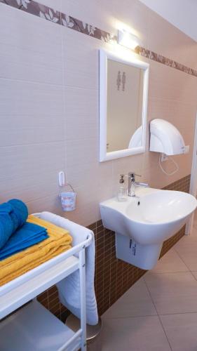 a white bathroom with a sink and a mirror at Lighthouse Ladispoli al centro in Ladispoli