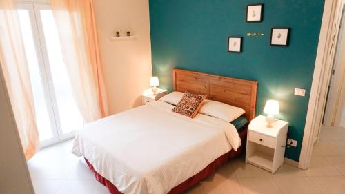 a bedroom with a bed and a green wall at Lighthouse Ladispoli al centro in Ladispoli