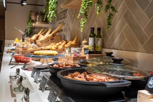 コルドビージャにあるホテル ベッドフォーユー パンプローナのテーブルの上に様々な種類の料理を揃えたビュッフェ
