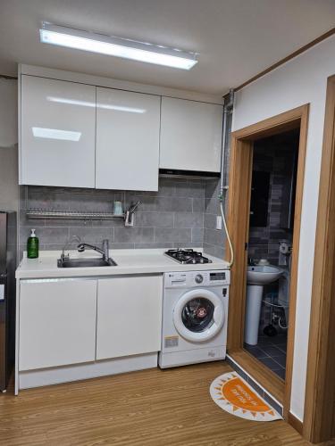 a kitchen with a stove and a washing machine at Urban Space Seolleung in Seoul
