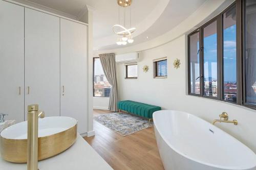 uma casa de banho com banheira e uma grande janela em 30% off Designer Penthouse - backup power - Cape Town na Cidade do Cabo