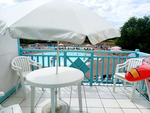d'une table, de deux chaises et d'un parasol sur le balcon. dans l'établissement 