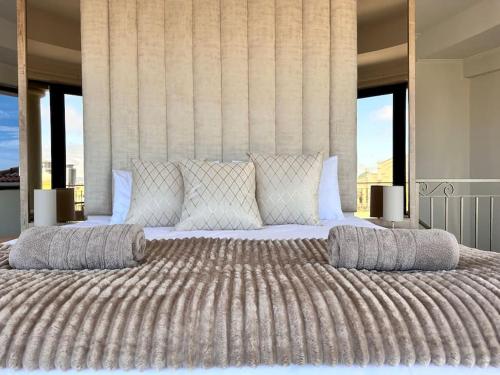 1 dormitorio con 1 cama grande y 2 almohadas en 30% off Designer Penthouse - backup power - Cape Town, en Ciudad del Cabo