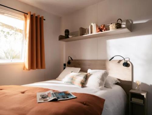 - une chambre avec un lit et un livre dans l'établissement Camping Le Soleil du Verdon, à Esparron-de-Verdon