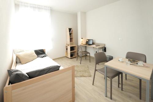 a room with a bed and a table and chairs at Apparteo Nancy in Nancy