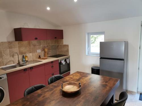 cocina con mesa de madera y nevera en L'Alcôve des Ondines, en Rochefort-sur-Nenon