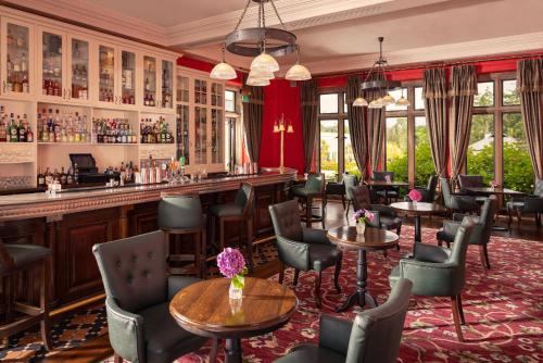 a bar in a restaurant with tables and chairs at Lough Eske Castle in Donegal