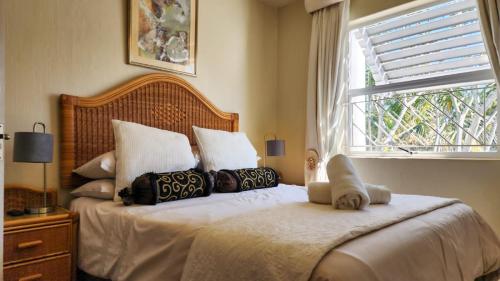 a bedroom with a bed with pillows and a window at Pelicans Pad at Chaka's Cove in Ballito
