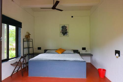 a bedroom with a bed and a ceiling fan at King's Landing for Pets in Karjat