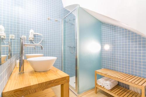a bathroom with a sink and a shower with blue tiles at Baluard-Apartment only 100 meters from the beach in Barcelona