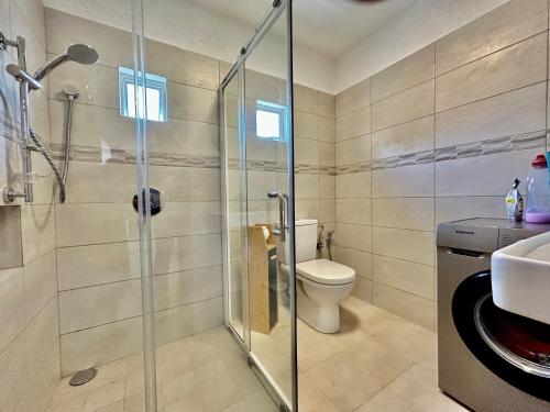 a bathroom with a shower and a toilet and a sink at Lakaz' Tamier in Flic-en-Flac