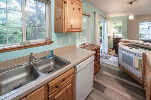 a kitchen with a stainless steel sink and wooden cabinets at Cozy Cannon Beach Condo in Cannon Beach