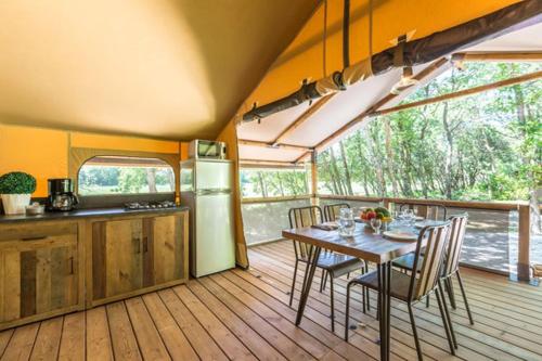 une cuisine et une salle à manger avec une table et des chaises dans l'établissement Camping Le Soleil du Verdon, à Esparron-de-Verdon