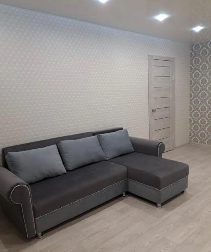 uma sala de estar com um sofá preto num quarto em VIP apart 342 em Tbilisi