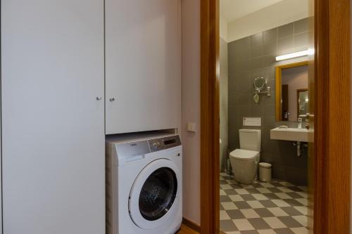 a bathroom with a washing machine and a sink at Le Port Boutique Apart Hotel in Batumi