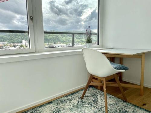 una silla blanca sentada en un escritorio frente a una ventana en Lokstadt, en Winterthur