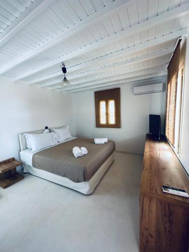 a bedroom with a large bed in a white room at Myconian Sunset Apartments in Tagou