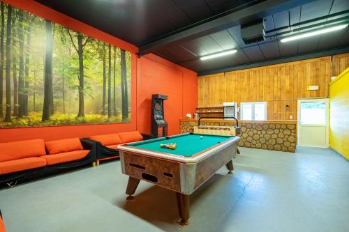 a pool table in a room with orange walls at Au Coeur du Bois in Rendeux