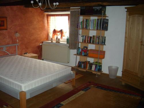 um quarto com uma cama e uma estante de livros com livros em Ferienhaus Zweite Straße em Neuenrade