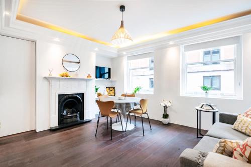 a living room with a table and a fireplace at Welcome London Covent Garden in London