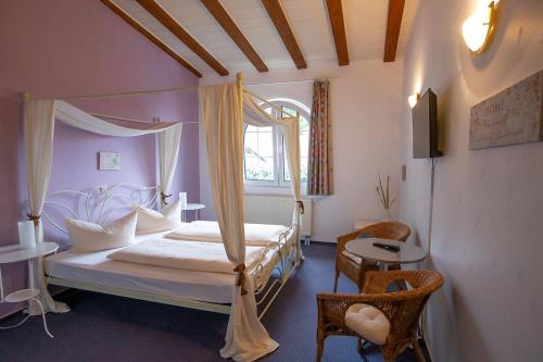 1 dormitorio con cama con dosel y ventana en Hotel Dolgesheim en Dolgesheim