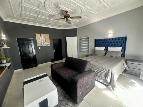 een slaapkamer met een bed, een bank en een plafond bij The Curve Apartments Unit 19 in Johannesburg