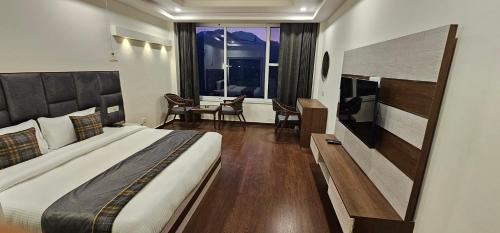 a bedroom with a large bed and a table with chairs at Tranquil Inn Mashobra in Shimla