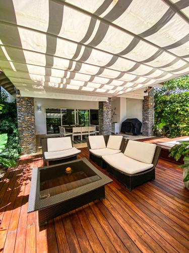 a patio with a couch and chairs on a wooden deck at Xeliter Balcones del Atlantico - Las Terrenas in Las Terrenas