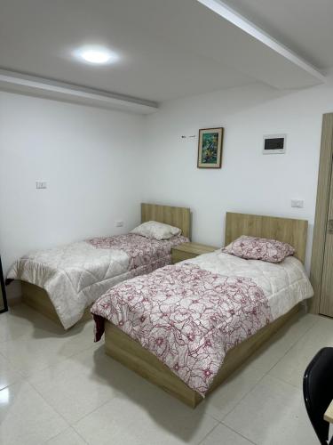 a room with two beds in a room at Karak Plaza Apartments in Kerak