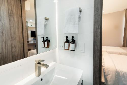 a bathroom with a sink and a mirror at Amari Living Suites in Barranquilla