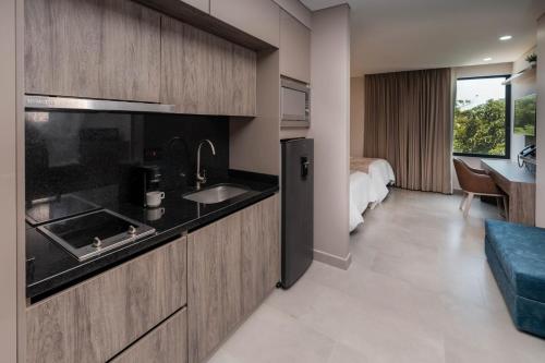 Habitación de hotel con cocina y dormitorio en Amari Living Suites en Barranquilla