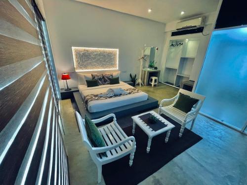 a living room with a bed and two chairs at 8 Plus Motels in Negombo