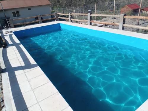 a swimming pool with blue water at Cabañas de Alta Montaña in Ciudad Lujan de Cuyo