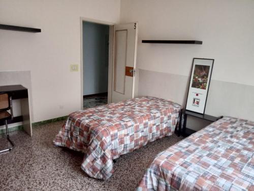 a hotel room with two beds and a desk at Casa Mawi in Modena