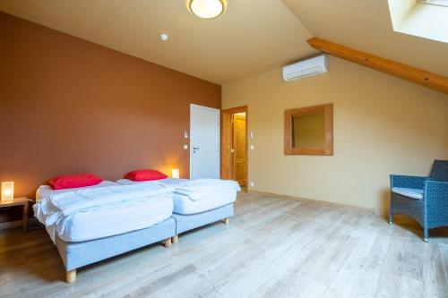 a bedroom with two beds and a table and a chair at Au Coeur du Bois in Rendeux