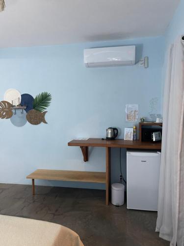 a room with a desk and a table with a microwave at Pousada Lanea Experience in Atins
