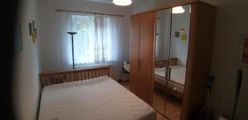ein kleines Schlafzimmer mit einem Bett und einem Fenster in der Unterkunft Ferienwohnung in Seenähe in Markkleeberg