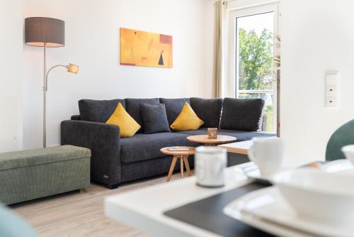 a living room with a blue couch and yellow pillows at Apartment "Haffliebe" - Haffresidenz in Garz