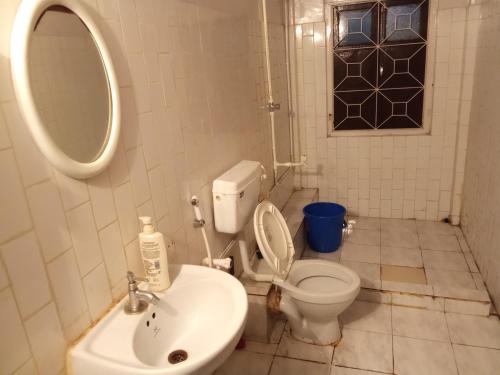 a bathroom with a white toilet and a sink at Sili hostel in Siliguri