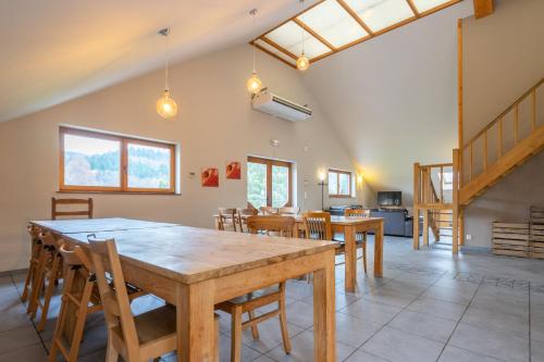 a kitchen and dining room with a wooden table and chairs at Au Coeur du Bois in Rendeux